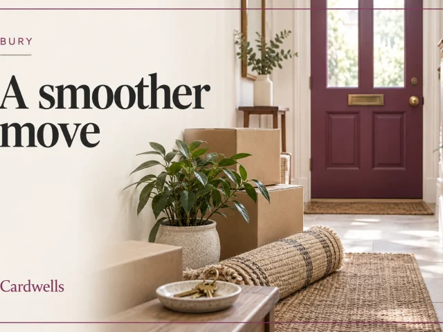 Moving boxes, a plant and a rug in a hallway with the words Bury, A smoother move and Cardwells.